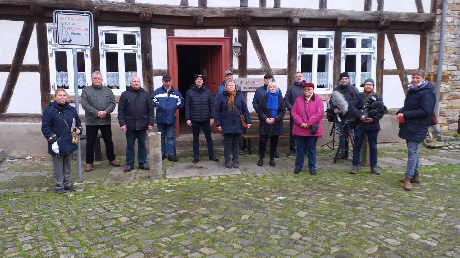 Aktive des Heimatvereins und das TV-Team vor dem Museum