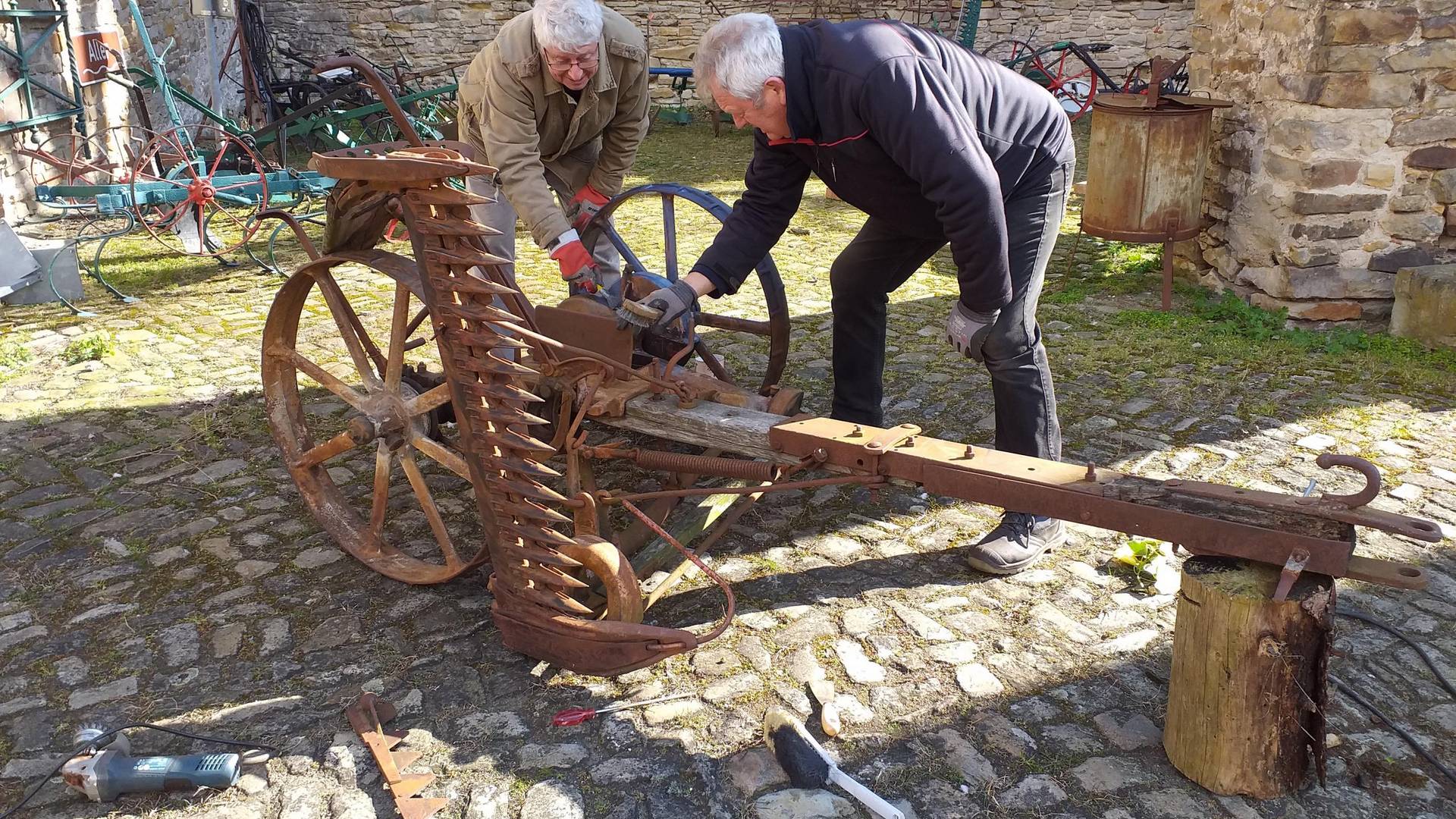 v.l.n.r.: Jürgen Müller und Bernd Bomballa  beim Entrosten und Rostschutzbehandlung am Mäher. © Heimatverein Oebisfelde