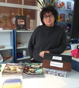 Marlies Hoffmann in ihrer Buchhandlung mit einem Spendenhäuschen, das dem Museum nachempfunden ist.